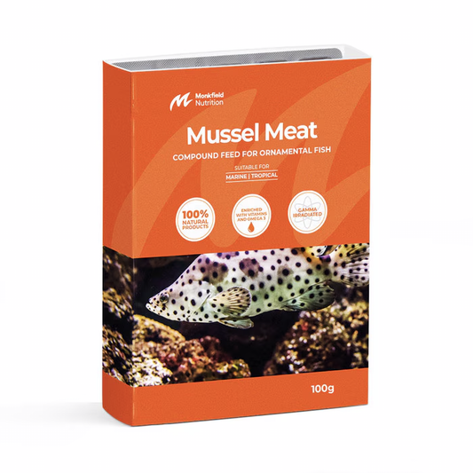 Packaging of Monkfield Nutrition Mussel Meat compound feed for ornamental fish, featuring an orange box with an image of a spotted fish swimming near rocks, suitable for marine and tropical fish, enriched with vitamins and omega-3, and gamma irradiated for safety.